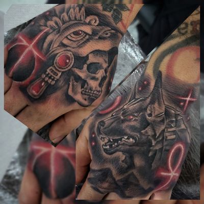 Two hand tattoos side by side, a skull in a feathered Aztec headdress and a jackal headed Anubis with red ankh symbols