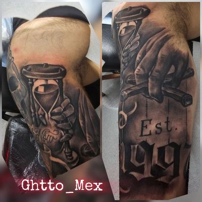 Black and grey sleeve in progress with a hand holding an hourglass and gothic Est. lettering