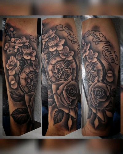 Black and grey forearm piece with a pocket watch, cherry blossoms, a rose and script name.