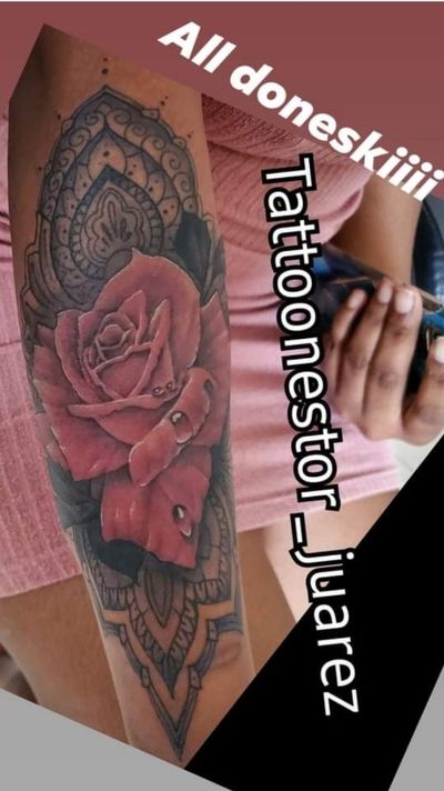 Red rose with water droplets over a black and grey ornamental mandala running down the inner forearm.