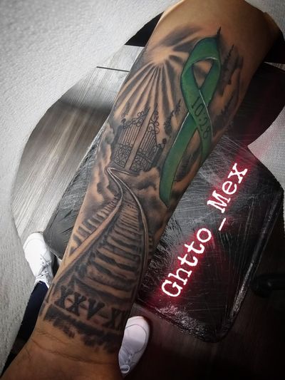 Forearm memorial with a stairway to heaven gates, sunrays, Roman numerals and a green awareness ribbon.