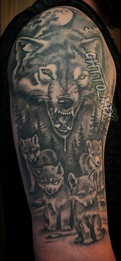 Snarling wolf with amber eyes above four pups in a pine forest under a full moon