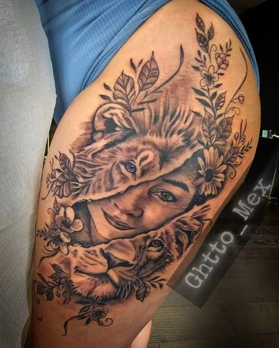 Thigh tattoo of a woman's face emerging from a lioness head with a cub below, daisies and leaves framing it
